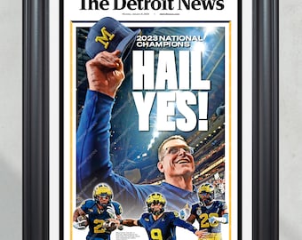 Puede incluir: Impresión enmarcada de la portada de The Detroit News, celebrando a los Campeones Nacionales de 2023. El titular dice "HAIL YES!" con una foto del equipo y del entrenador. Un gorro azul con una "M" amarilla se levanta en el aire.