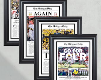May include: Four framed newspaper front pages from The Michigan Daily, each with a different headline and photo. The headlines are "30", "AGAIN", "53", and "GO FOR FOUR".