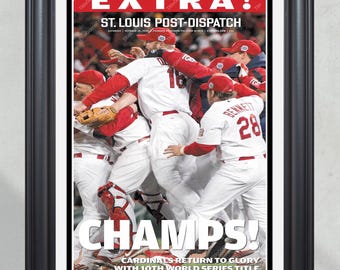 以下が含まれることがあります： 「EXTRA!」という見出しと「ST. LOUIS POST-DISPATCH」という副題が書かれた、ビンテージの新聞の第一面。メインの画像は、野球選手たちが勝利を祝っている様子で、「CHAMPS! CARDINALS RETURN TO GLORY WITH 10TH WORLD SERIES TITLE」というテキストが画像の下に書かれている。