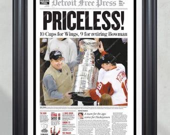 Op de afbeelding: Ingelijste krantenprint in een zwart frame. De kop luidt "PRICELESS!" met het logo van de Detroit Free Press en "STANLEY CUP CHAMPIONS". De afbeelding toont hockeyspelers die de Stanley Cup vasthouden. Tekst bevat "10 Cups for Wings, 9 for retiring Bowman."