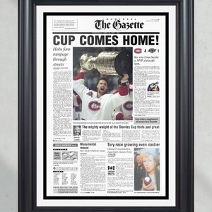 May include: A black and white newspaper front page with the headline "CUP COMES HOME!"  The main image shows a hockey player holding up the Stanley Cup trophy. The newspaper is from The Gazette, 16 June 1993.