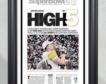 May include: A black and white newspaper clipping from the Pittsburgh Post-Gazette, dated February 6, 2005, celebrating the Pittsburgh Steelers Super Bowl XL victory. The headline reads "Super Bowl Xtra HIGH 5" and features a photo of Steelers quarterback Ben Roethlisberger kissing the Vince Lombardi Trophy. The article highlights the Steelers' victory over the Seattle Seahawks, 21-10, and the team's first Super Bowl championship under coach Bill Cowher.