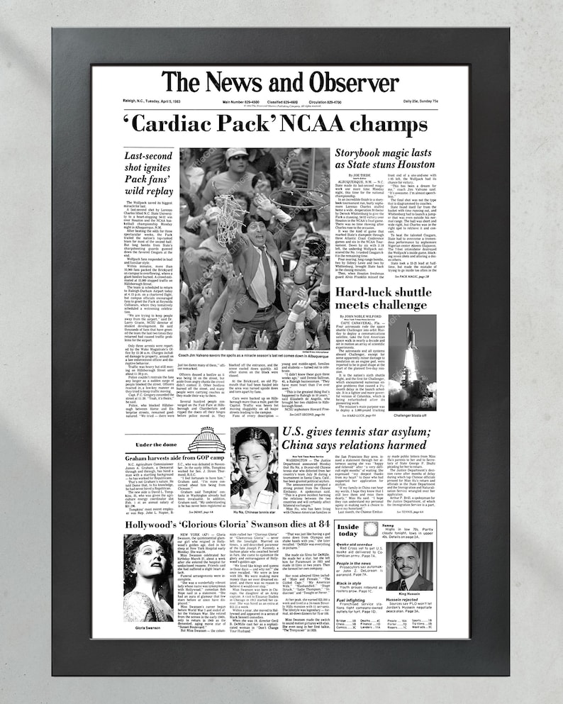 May include: A black and white newspaper clipping from The News and Observer, dated Tuesday, April 2, 1991. The headline reads "'Cardiac Pack' NCAA champs". The article discusses the University of Nevada, Las Vegas's victory in the NCAA men's basketball championship game. Other articles include "Storybook magic lasts as State stuns Houston", "Hard-luck shuttle meets challenge", "U.S. gives tennis star asylum; China says relations harmed", and "Hollywood's 'Glorious Gloria' Swanson dies at 84".