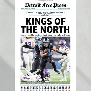 May include: A newspaper front page from the Detroit Free Press. The headline reads "KINGS OF THE NORTH" with a photo of a football game. The score is 31-9. The article is about the Detroit Lions.