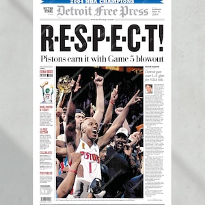 Może przedstawiać: Pierwsza strona gazety Detroit Free Press, świętująca mistrz&oacute;w NBA 2004. Nagł&oacute;wek brzmi "R-E-S-P-E-C-T!" ze zdjęciem drużyny Pistons świętującej zwycięstwo. Artykuł szczeg&oacute;łowo opisuje grę 5.