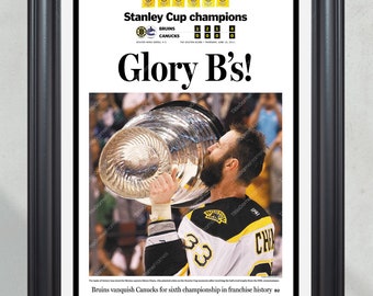 Puede incluir: Un titular de periódico que anuncia a los Boston Bruins como campeones de la Copa Stanley. El titular dice "Glory B's!" y muestra una foto de un jugador de hockey sosteniendo el trofeo de la Copa Stanley por encima de su cabeza. La tarjeta de puntuación muestra a los Bruins ganando la serie 4-0.