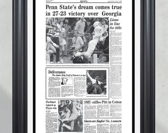 Peut inclure: Impression encadrée en noir et blanc d'un article de journal sportif. Le titre est : "Le rêve de Penn State devient réalité avec une victoire 27-23 contre la Géorgie". D'autres articles et photos sont inclus.