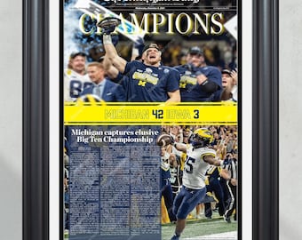 May include: A newspaper front page with the headline "CHAMPIONS" and the text "MICHIGAN 42 IOWA 3". The newspaper is from "The Michigan Daily" and features a photo of a football player celebrating a victory.