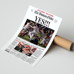 May include: A newspaper print of The Boston Globe's Victory Edition, celebrating the Red Sox's World Series win. The headline reads "YES!!!" with a photo of the team celebrating. The print is rolled up with a brown cardboard tube.