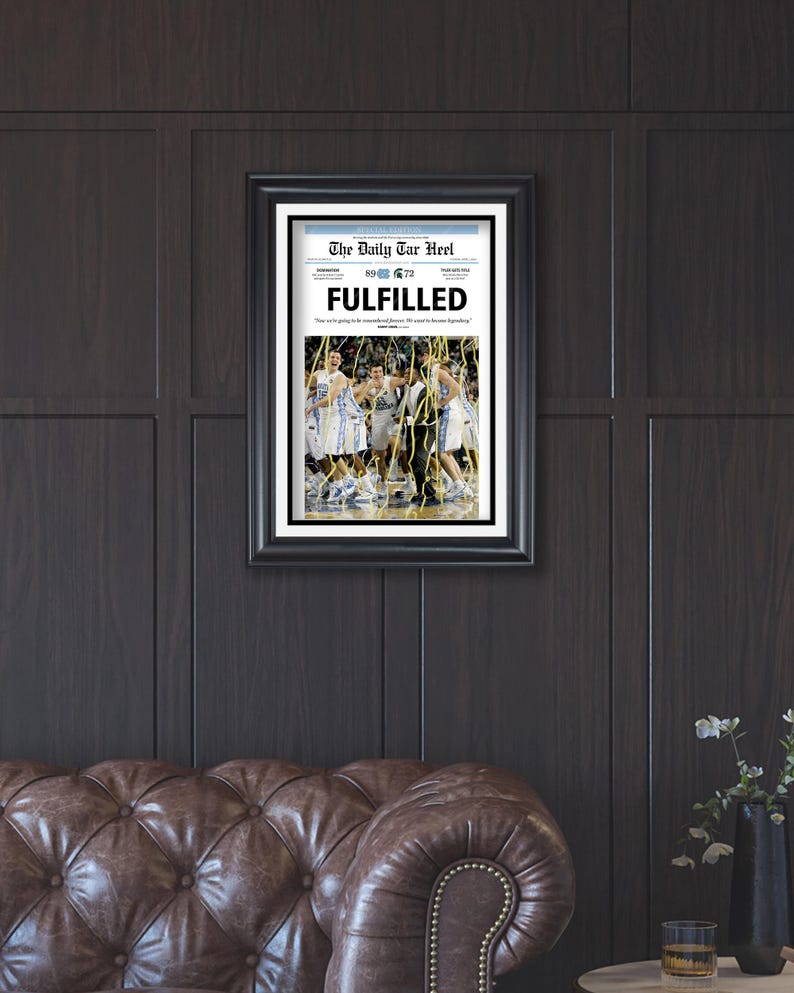 May include: A framed newspaper clipping from The Daily Tar Heel, dated March 30, 2009, with the headline "FULFILLED". The image shows a group of basketball players celebrating on the court.