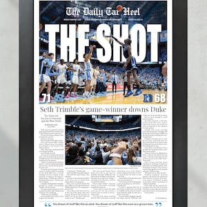 May include: A framed newspaper page titled "The Daily Tar Heel" with the headline "THE SHOT." The image shows a basketball game with the score 71-68. Text reads "Seth Trimble's game-winner downs Duke." A quote at the bottom says, "You dream of stuff like this as a kid."