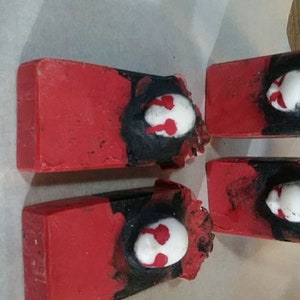 May include: Four rectangular red bars with a black and white design. The bars have a white oval shape with red accents. The bars are arranged on a white surface.