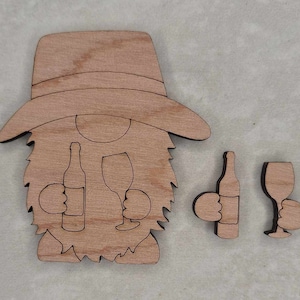 May include: Wooden gnome cutout with a hat, beard, and arms holding a wine bottle and glass. Two additional cutouts of a wine bottle and glass.