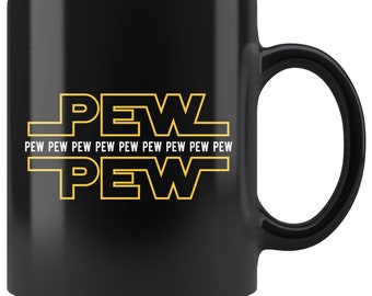 May include: Black ceramic coffee mug with a yellow graphic of the word "PEW" repeated multiple times. The text "PEW PEW PEW PEW PEW PEW PEW PEW PEW" is printed in white below the graphic.