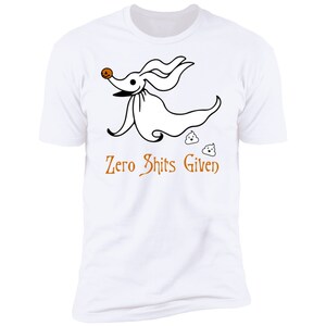 May include: White t-shirt featuring a black and white cartoon ghost dog with a pumpkin nose and the text "Zero Shits Given".