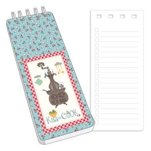 May include: A blue and red patterned notepad with a spiral binding. The front cover features an illustration of a vintage stove with the text "Kiss the Cook". The notepad has a blank lined page on the right side.