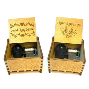 Puede incluir: Dos cajas de música de madera con un diseño floral y las palabras "Auld Lang Syne" grabadas en la tapa. Las cajas están abiertas y los mecanismos de música son visibles.