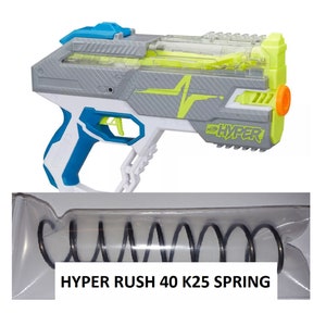May include: A white, gray, and blue Nerf Hyper Rush 40 K25 spring-powered blaster with a clear barrel and a yellow and black lightning bolt design. The blaster has a black spring in a clear plastic bag labeled "HYPER RUSH 40 K25 SPRING".