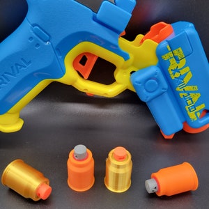 May include: A blue and yellow toy blaster with the words "NERF RIVAL" printed on the side. Four orange and gold darts are in the foreground.
