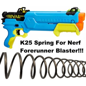 May include: A black spring for a Nerf Rival Foreunner blaster. The spring is coiled and ready to be installed. The text "K25 Spring For Nerf Forerunner Blaster!!!" is written below the spring.