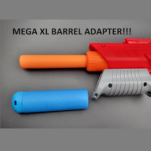 Op de afbeelding: Een rood en grijs speelgoedpistool met een oranje loopadapter en een blauwe schuimrubberen loopverlenging. De tekst "MEGA XL BARREL ADAPTER!!!" wordt boven het speelgoedpistool weergegeven.
