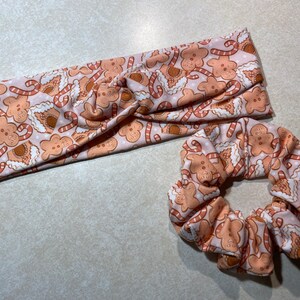 May include: A pink headband and scrunchie with a gingerbread man and candy cane print.