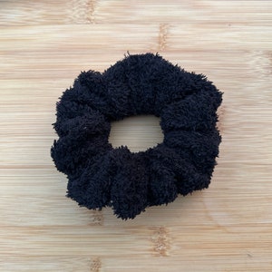 May include: A black fuzzy scrunchie hair tie.