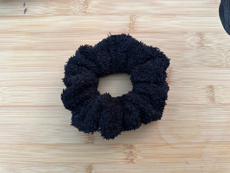 May include: A black fuzzy scrunchie hair tie.