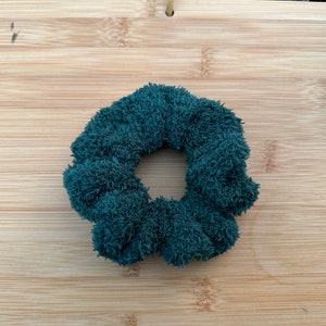 May include: A dark green fuzzy hair scrunchie.