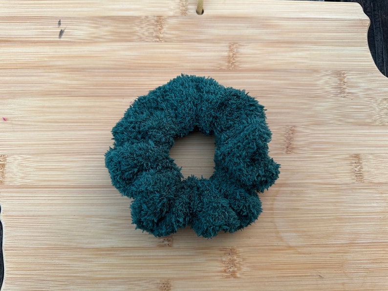 May include: A dark green fuzzy hair scrunchie.