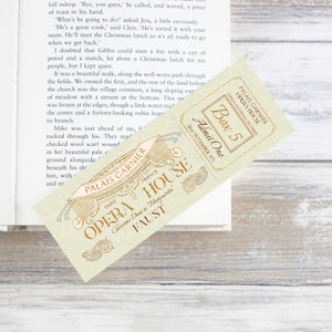 May include: A vintage-style ticket for the opera house in Paris, France. The ticket is cream-coloured with gold lettering and a blue and gold design. The ticket reads "Palais Garnier Opera House, Opera National de Paris, Box 5, Admit One, 30th September 1891".
