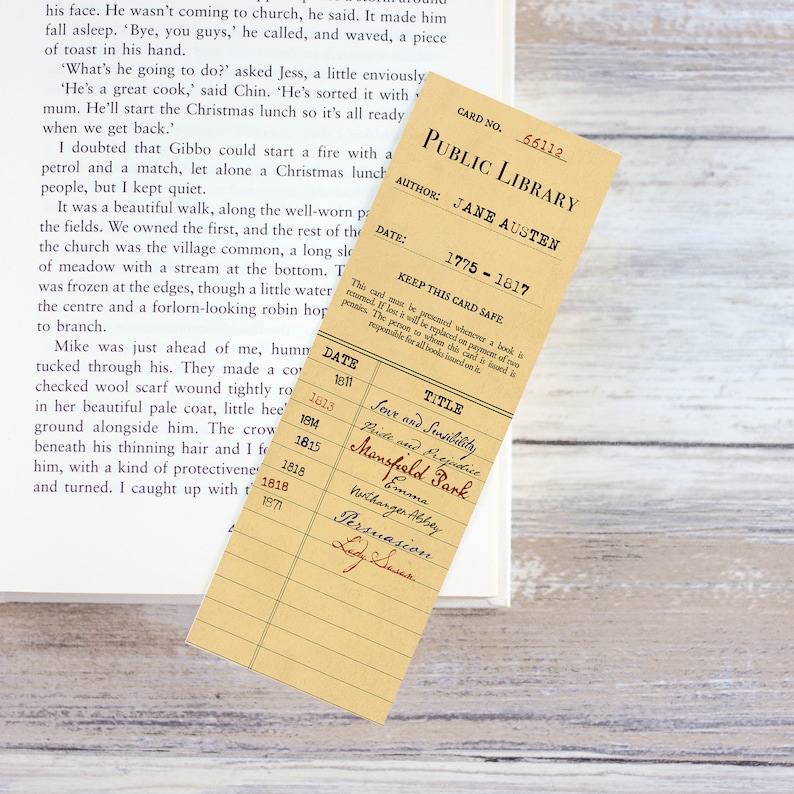 Op de afbeelding: Een vintage bibliotheekkaart met de titel "Pride and Prejudice" van Jane Austen. De kaart is bruin met witte tekst en bevat de publicatiedatum 1813.