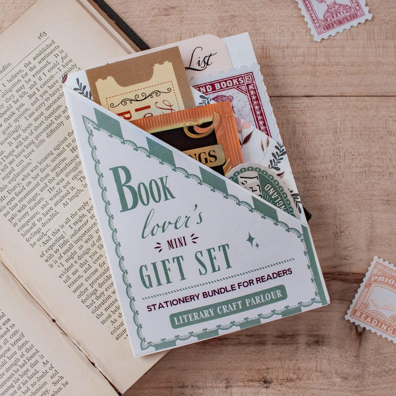 A book lover's mini gift set stationery bundle for readers, packaged in a blind date with a book style pocket, styled on a wooden tabletop next to an open vintage book with decorative postage stamps.