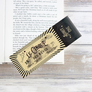 Peut inclure: Un billet de style vintage pour "Le Cirque des Rêves" avec des rayures noires et blanches, une étoile dorée et le texte "ADMIT ONE" en noir. Le billet est pour un cirque qui ouvre à la tombée de la nuit et ferme à l'aube.