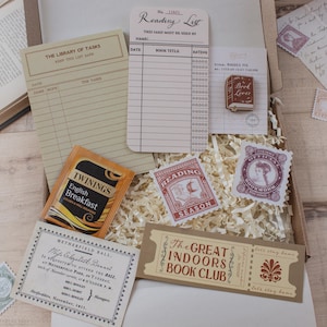 May include: A stationery gift box containing a Library of Tasks notepad, a Reading List card, a wooden Book Lover pin, a Twinings English Breakfast tea bag, a Reading Season sticker, a Bookworm stamp, a Netherfield Ball invitation, and a ticket.