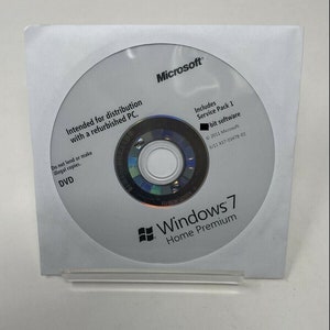 May include: A Microsoft Windows 7 Home Premium DVD in a white paper sleeve. The disc includes Service Pack 1 software and is intended for distribution with a refurbished PC. The DVD is labeled with the Microsoft logo.