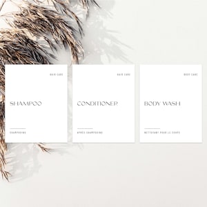 May include: Three white labels with black text. The labels are for shampoo, conditioner, and body wash. The text on the labels reads "Hair Care", "Shampoo", "Shampooing", "Hair Care", "Conditioner", "Après-Shampooing", "Body Care", "Body Wash", and "Nettoyant pour le Corps".