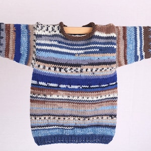 Könnte beinhalten: Ein gestrickter Pullover mit Streifen in den Farben Blau, Braun und Weiß. Der Pullover hat einen runden Ausschnitt und lange Ärmel.