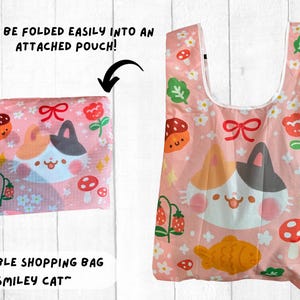May include: A pink foldable shopping bag with a white and black cat design. The bag has a floral pattern and the text "SMILEY CAT" is printed on the bottom. The bag can be folded into a small pouch.