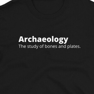 May include: Black t-shirt with white text that reads "Archaeology The study of bones and plates."