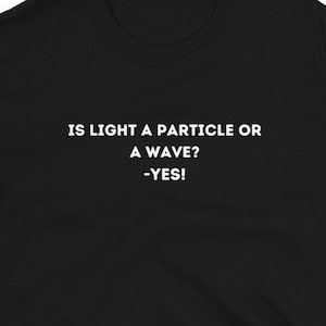 Könnte beinhalten: Schwarzes T-Shirt mit weißem Text, der "IS LIGHT A PARTICLE OR A WAVE? -YES!" lautet.