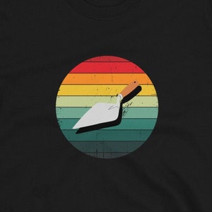 Peut inclure: T-shirt noir avec un graphique de truelle vintage dans un cercle avec un schéma de couleurs arc-en-ciel.