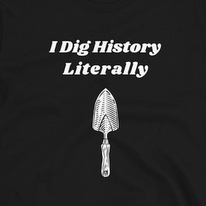 May include: Black t-shirt with white text that reads "I Dig History Literally" and a small image of a shovel.