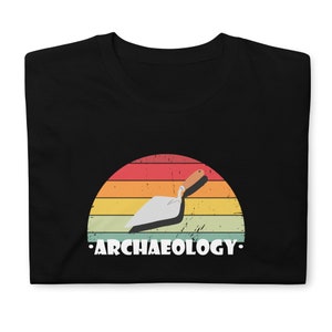 Peut inclure: T-shirt noir avec un graphique de coucher de soleil de style vintage représentant une truelle et le texte "ARCHAEOLOGY."