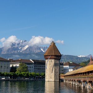 Kapellbrucke timber bridge in Lucerne, Switzerland with the Alpes in the background.