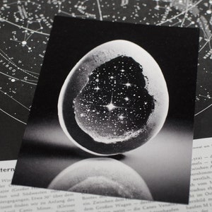 Cartolina mitologica dell'uovo mondiale, carta riciclata, uovo celeste metafisico con Universo al suo interno, simbolo di creazione, nascita e trasformazione