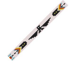 May include: A beaded bracelet featuring a black and white eagle design and a colourful arrow design. The bracelet is made with white beads and features black, yellow, red, blue and green beads.
