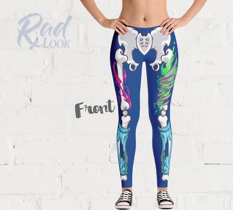 Pode incluir: Leggings azuis com um design de esqueleto com respingos de tinta rosa e verde. As leggings t&ecirc;m um visual rasgado com um padr&atilde;o azul e branco.