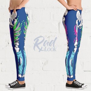 Pode incluir: Leggings azuis com um design de esqueleto e respingos de tinta coloridos. O esqueleto est&aacute; vestindo jeans azul.