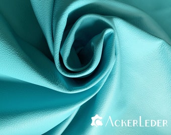 May include: Close-up of a turquoise leather fabric, showing the texture and folds of the material.